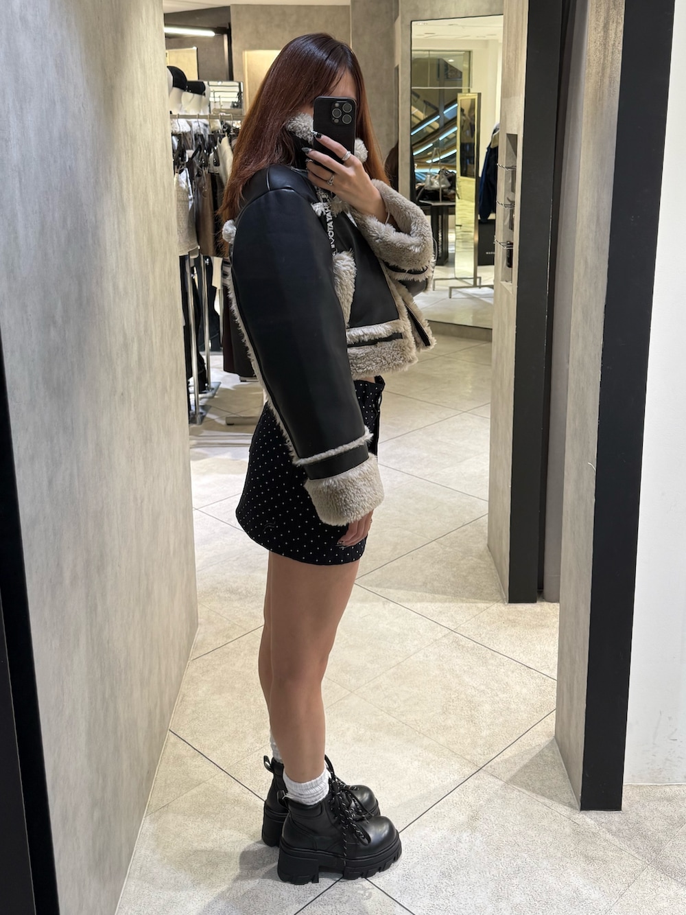 その他のブルゾン、ブルー系のスカート、ブラック系のブーツを着用したレディースの秋コーディネートの2枚目の写真