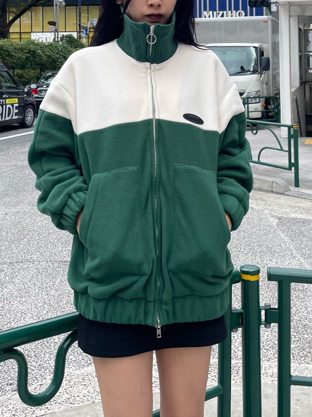 グリーン系のブルゾン、ブラック系のスカート、その他のブーツを着用したレディースの秋コーディネートの5枚目の写真