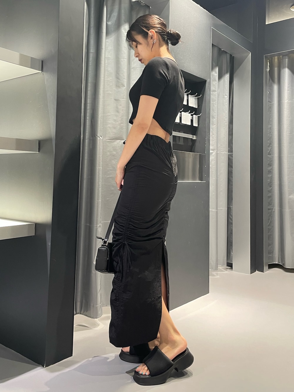 ブラック系のTシャツ/カットソー、ブラック系のスカート、ブラック系のサンダルを着用したレディースの夏コーディネートの2枚目の写真