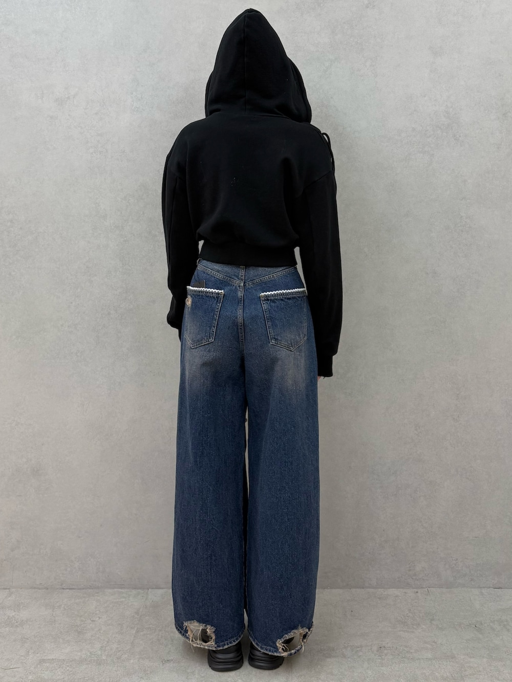 ブラック系のパーカー、ブルー系のデニムパンツ、ブラック系のローファーを着用したレディースの冬コーディネートの3枚目の写真