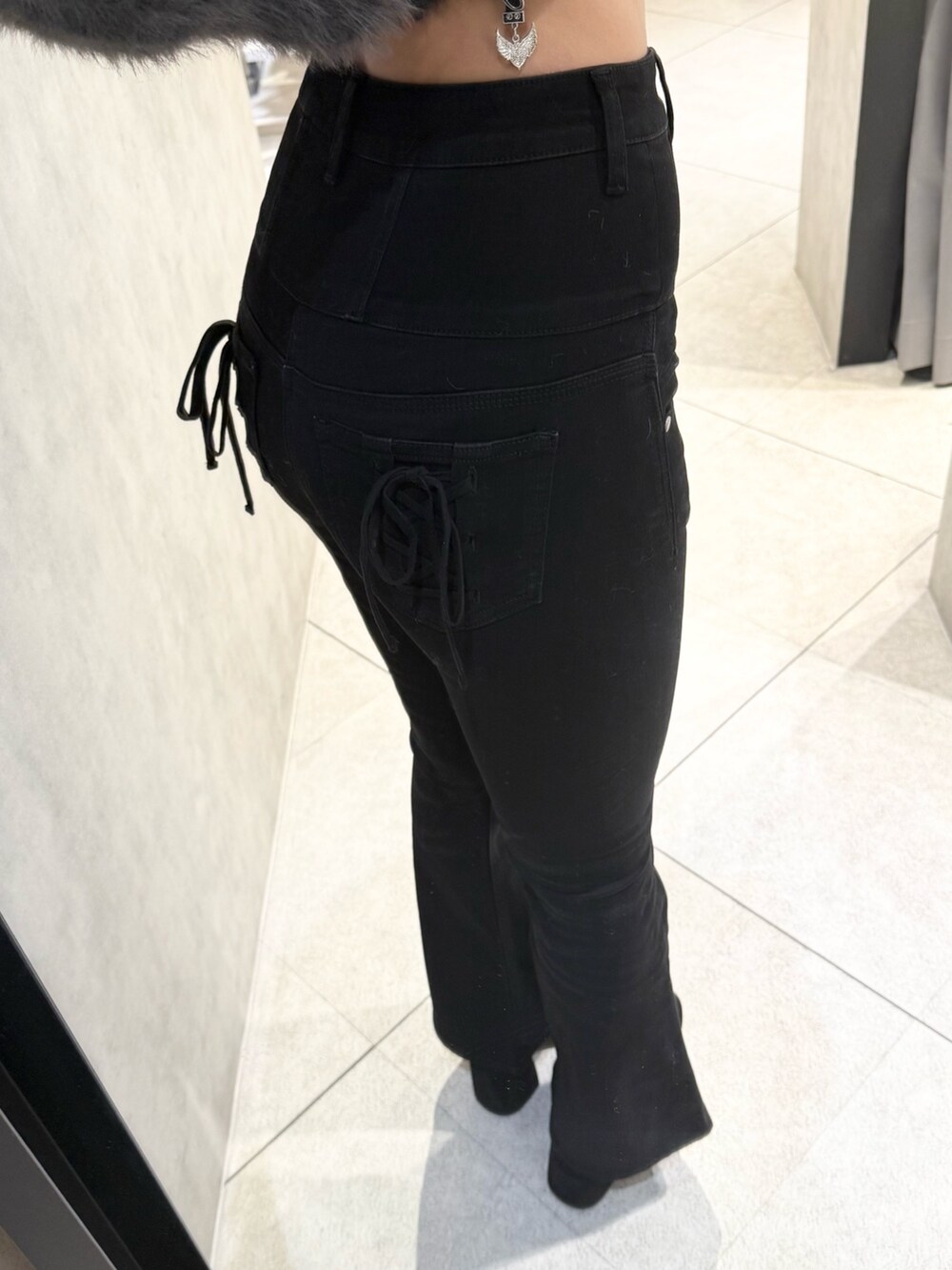 ブラウン系のニット/セーター、ブラック系のデニムパンツ、ブラック系のブーツを着用したレディースの秋コーディネートの7枚目の写真