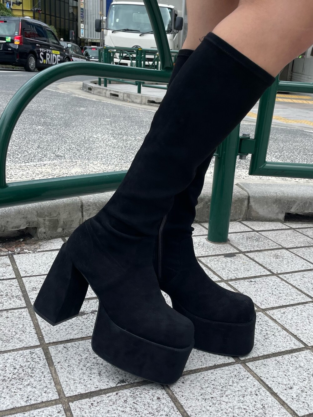 グリーン系のブルゾン、ブラック系のスカート、その他のブーツを着用したレディースの秋コーディネートの7枚目の写真