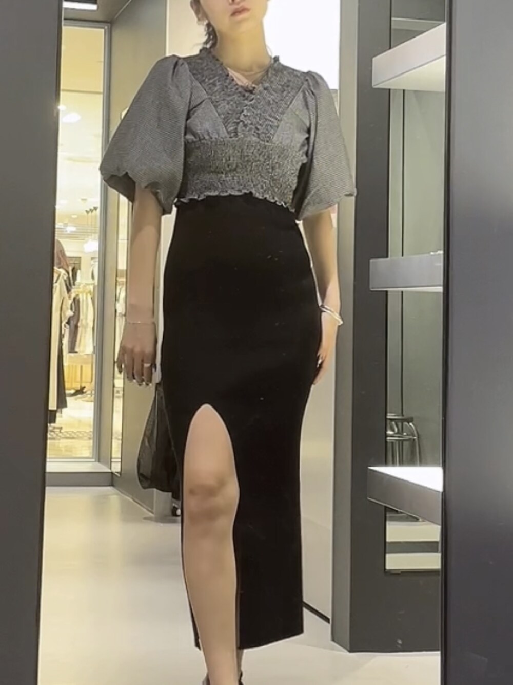 ブラック系のワンピース、ブラック系のTシャツ/カットソー、ブラック系のサンダルを着用したレディースの夏コーディネートの3枚目の写真