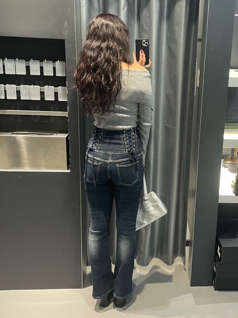 グレー系のニット/セーター、ブルー系のデニムパンツ、シルバー系のショルダーバッグを着用したレディースの冬コーディネートの3枚目の写真