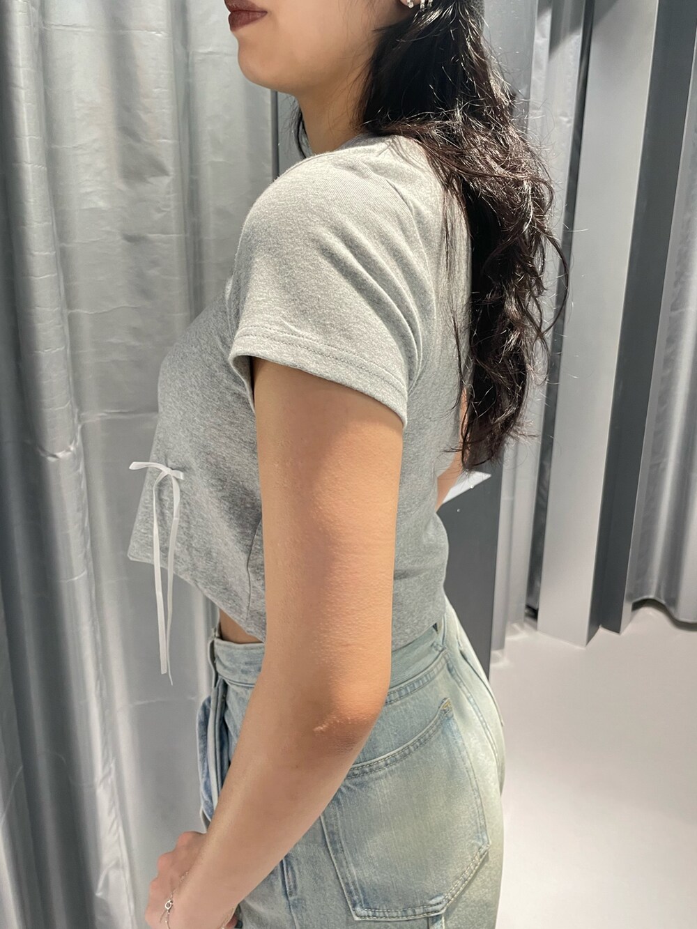 グレー系のTシャツ/カットソー、ブルー系のデニムパンツ、ホワイト系のサンダルを着用したレディースの夏コーディネートの5枚目の写真