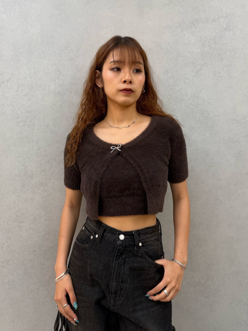 ブラウン系のニット/セーター、ブラック系のデニムパンツ、ブラウン系のブーツを着用したレディースの夏コーディネートの4枚目の写真