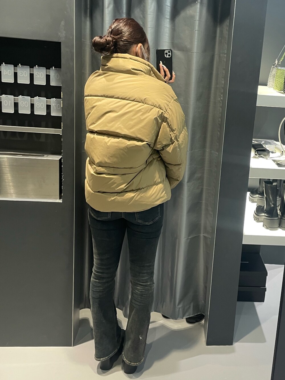 ブラック系のニット/セーター、ベージュ系のブルゾン、ブルー系のデニムパンツを着用したレディースの冬コーディネートの6枚目の写真