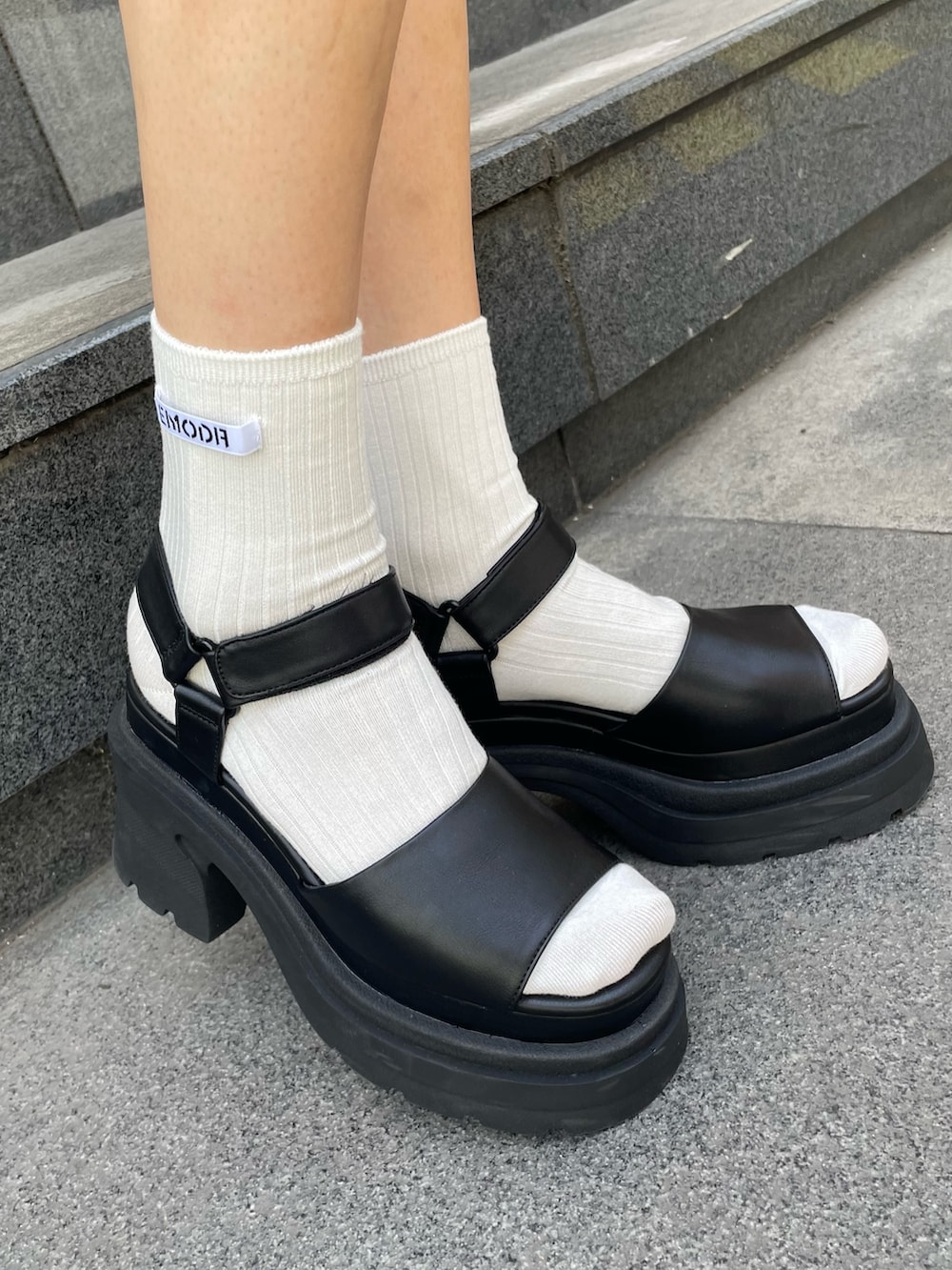 ブラック系のサンダル、ブラック系のTシャツ/カットソー、ブラック系のハンドバッグを着用したレディースの夏コーディネートの5枚目の写真