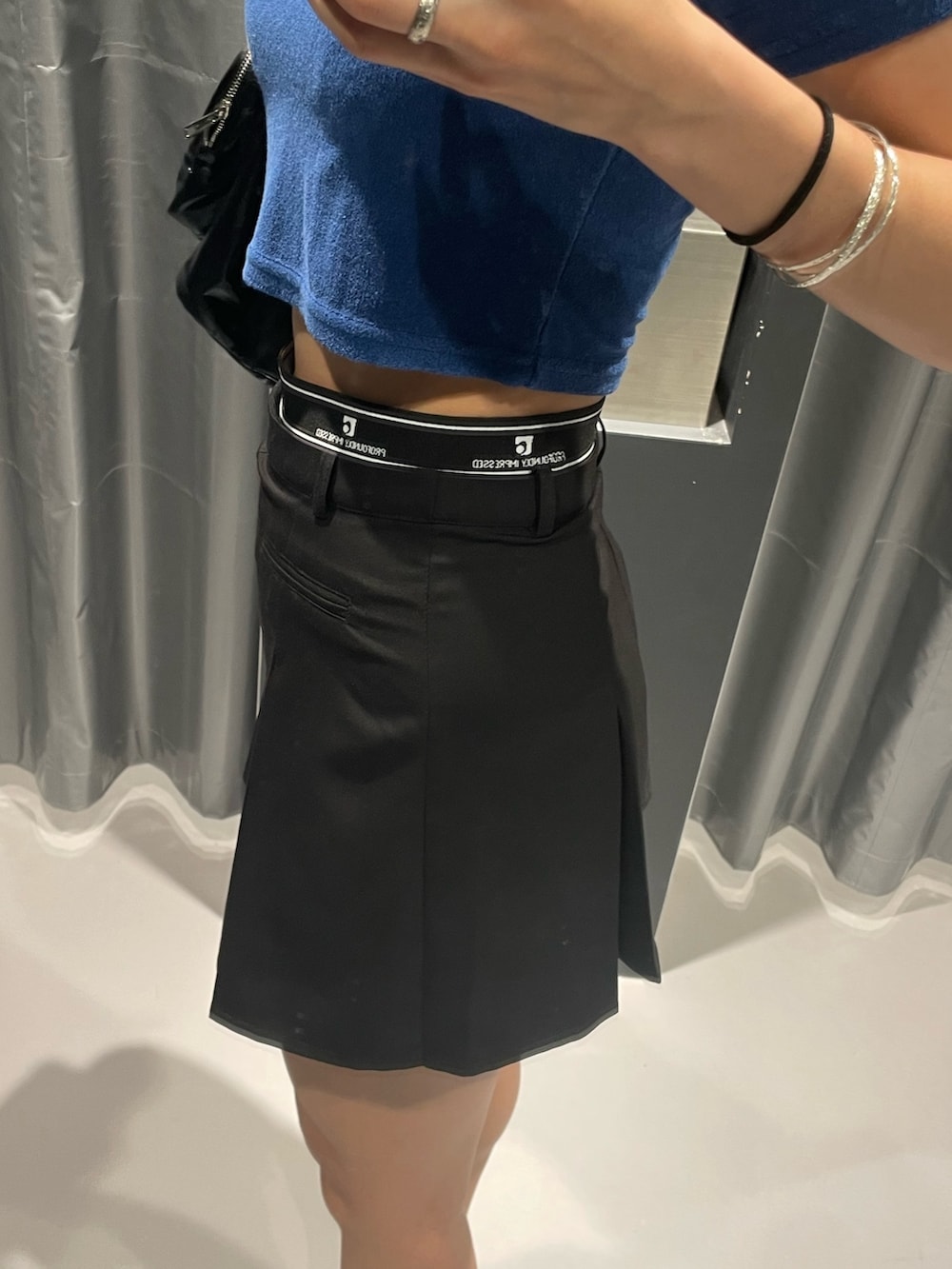 ブルー系のTシャツ/カットソー、ブラック系のハンドバッグ、ブラック系のスカートを着用したレディースの夏コーディネートの7枚目の写真