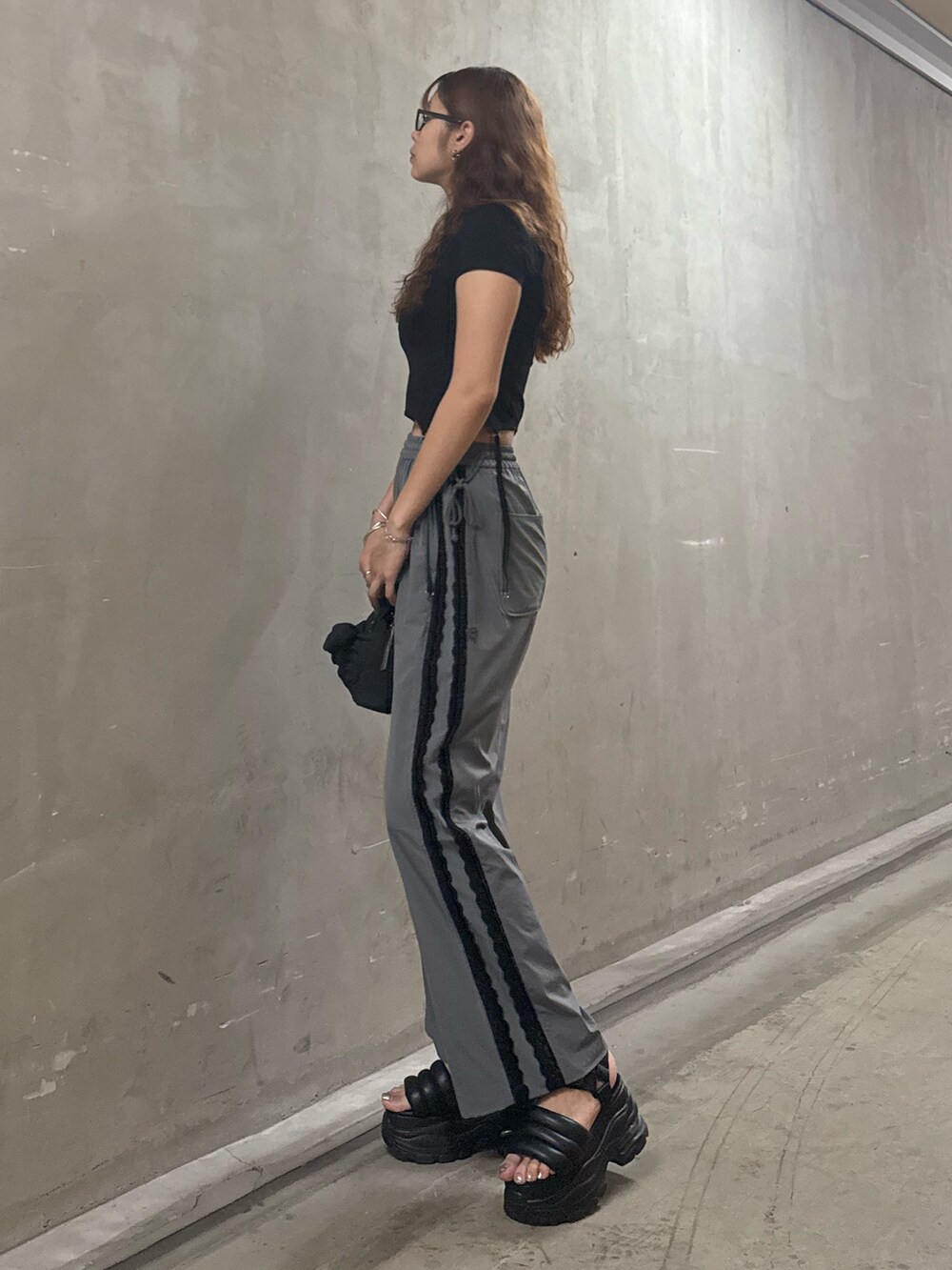 ブラック系のTシャツ/カットソー、グレー系のその他パンツ、ブラック系のハンドバッグを着用したレディースの夏コーディネートの2枚目の写真