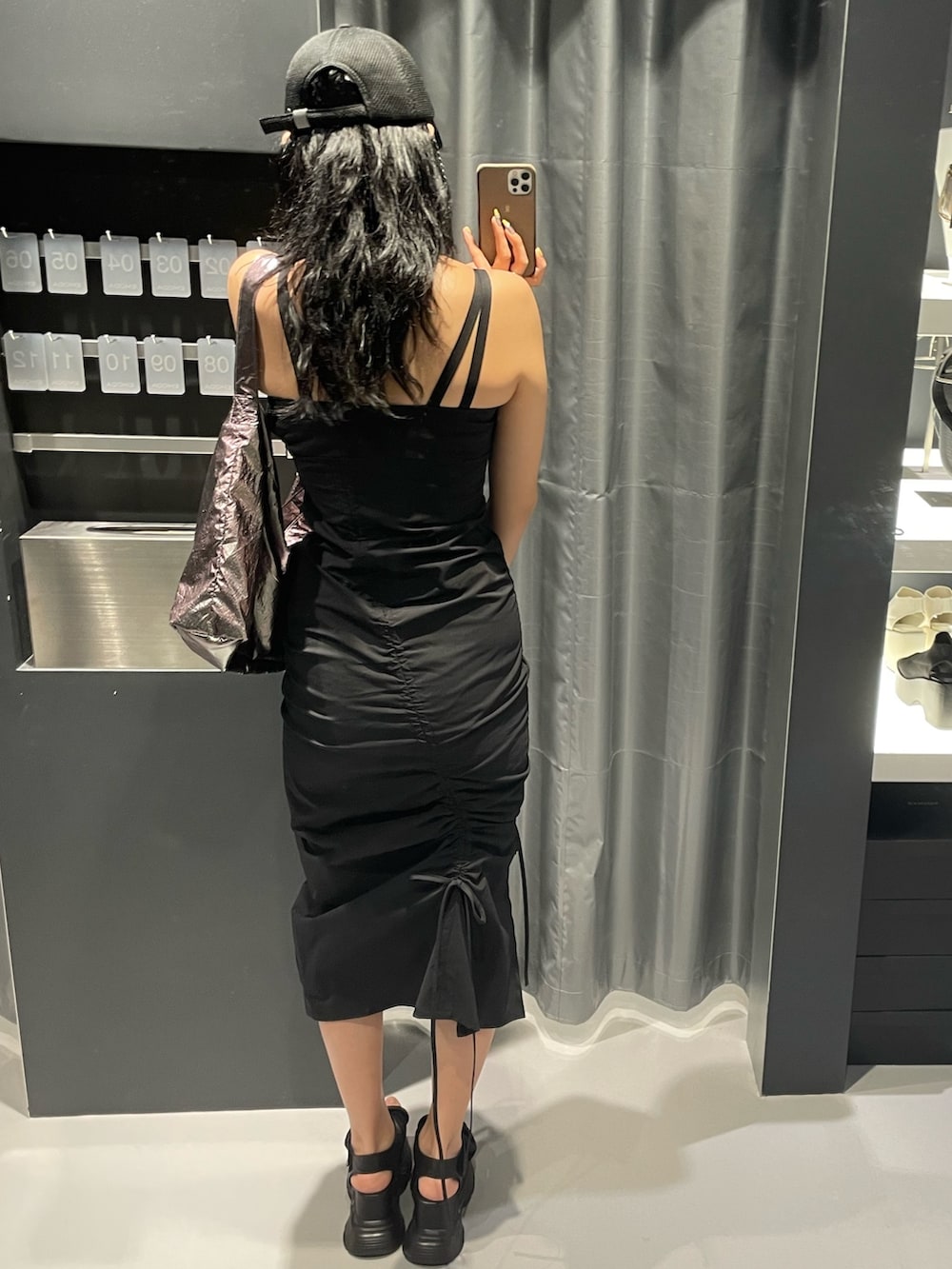 ブラック系のワンピース、グレー系のハンドバッグ、ブラック系のサンダルを着用したレディースの春コーディネートの3枚目の写真