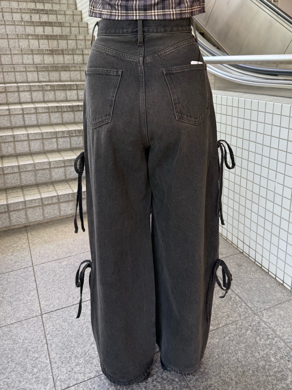 ブラウン系のタンクトップ、ブラック系のハンドバッグ、ブラック系のデニムパンツを着用したレディースの夏コーディネートの9枚目の写真