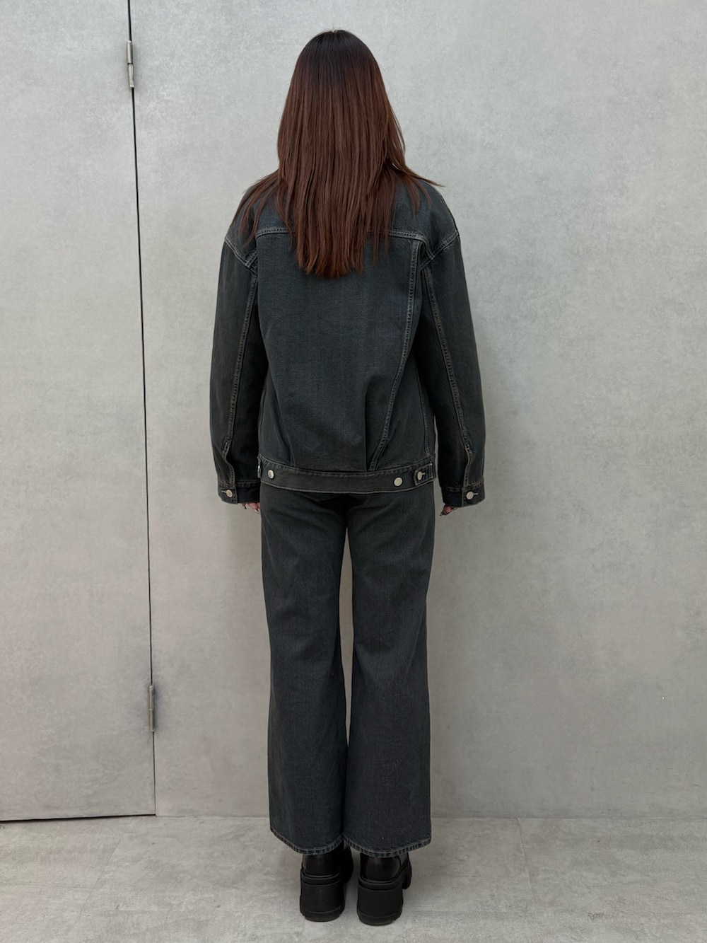 ブラック系のニット/セーター、ブルー系のブルゾン、ブルー系のデニムパンツを着用したレディースの冬コーディネートの3枚目の写真