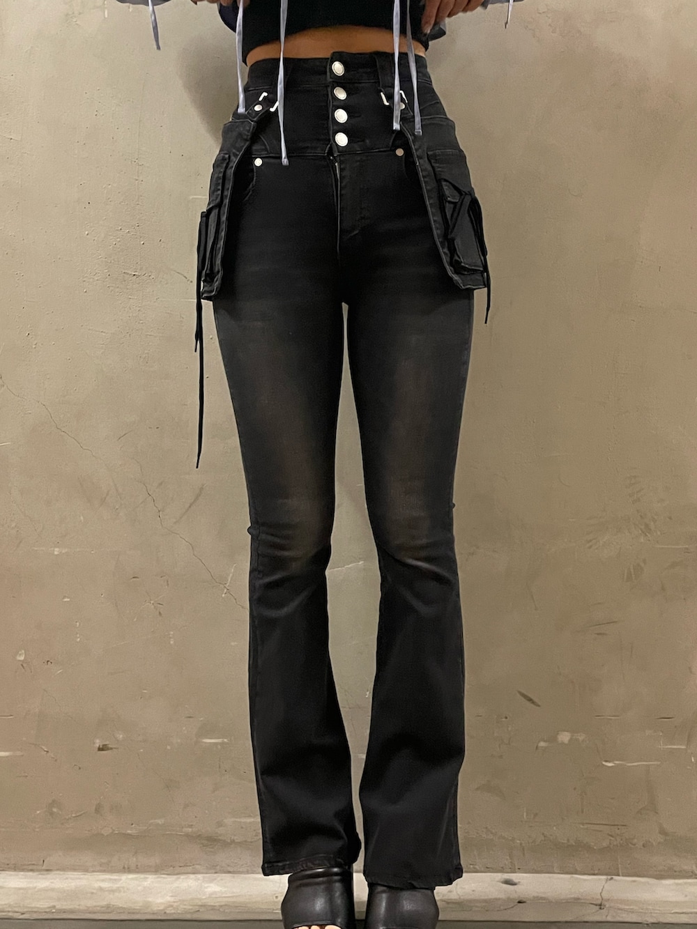 グリーン系のニット/セーター、ブラック系のデニムパンツ、ブラック系のサンダルを着用したレディースの春コーディネートの7枚目の写真