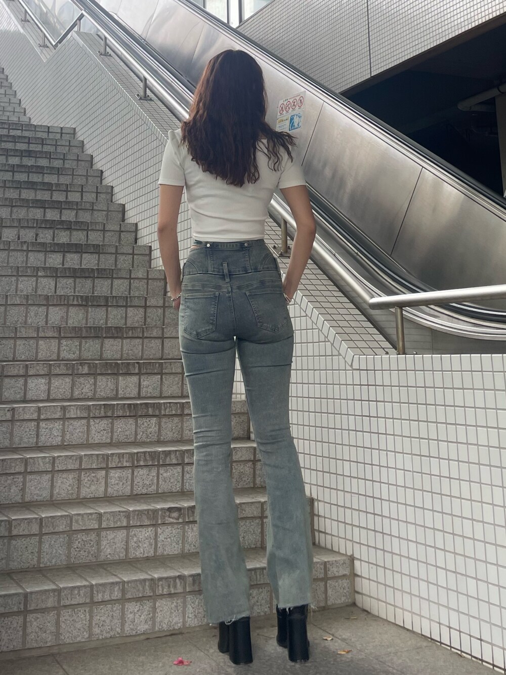 ホワイト系のTシャツ/カットソー、ブルー系のデニムパンツ、ブラック系のサンダルを着用したレディースの春コーディネートの3枚目の写真