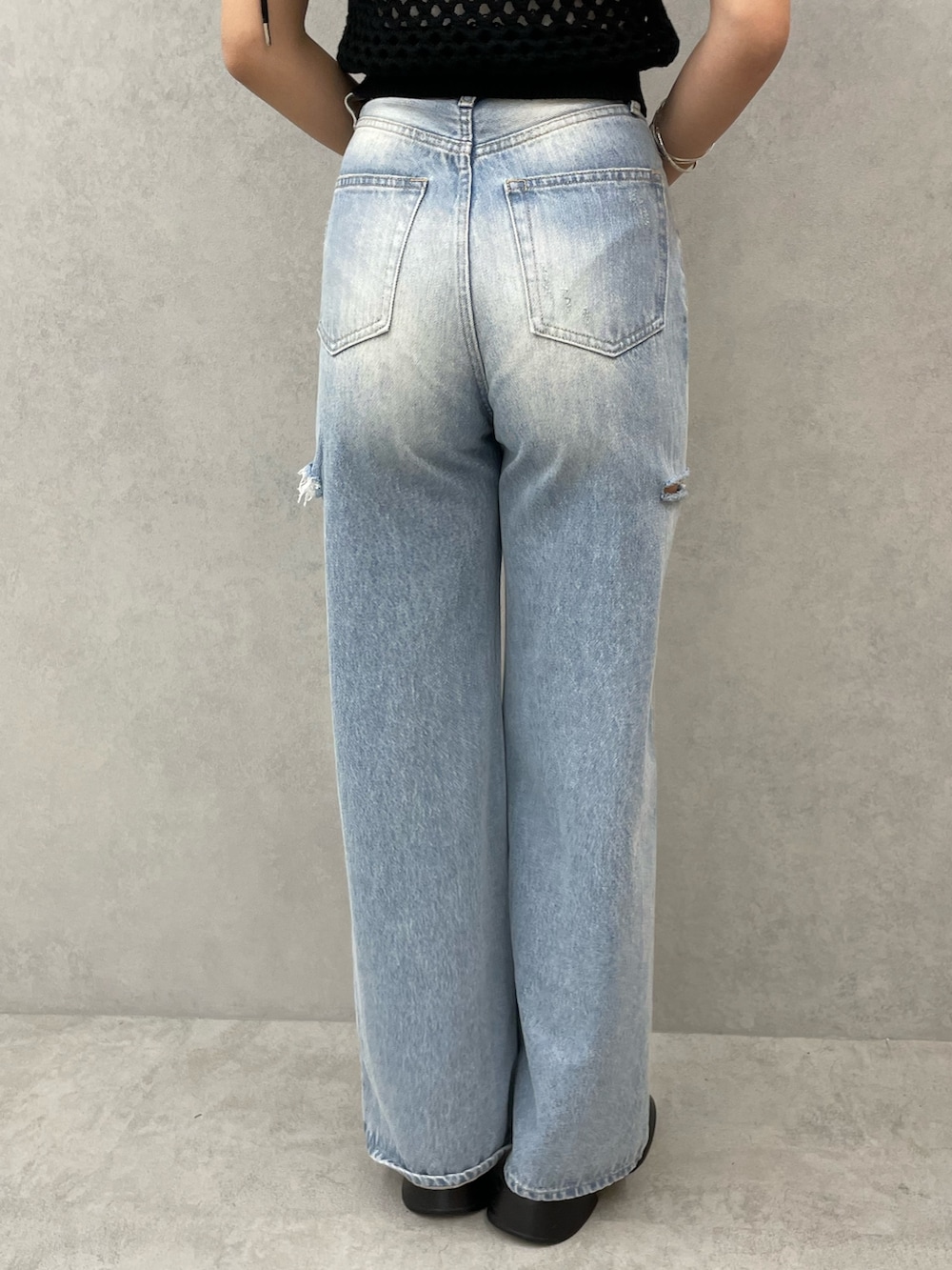 ブラック系のタンクトップ、ホワイト系のキャミソール、ブルー系のデニムパンツを着用したレディースの春コーディネートの9枚目の写真