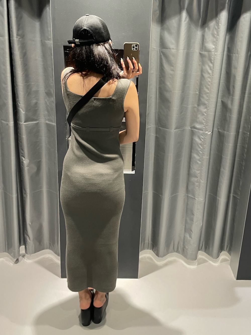 ブラック系のハンドバッグ、グレー系のワンピース、ブラック系のサンダルを着用したレディースの春コーディネートの3枚目の写真