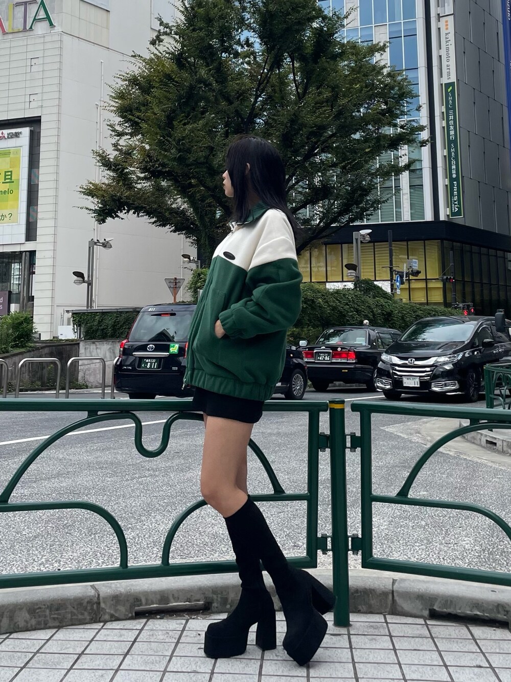 グリーン系のブルゾン、ブラック系のスカート、その他のブーツを着用したレディースの秋コーディネートの2枚目の写真