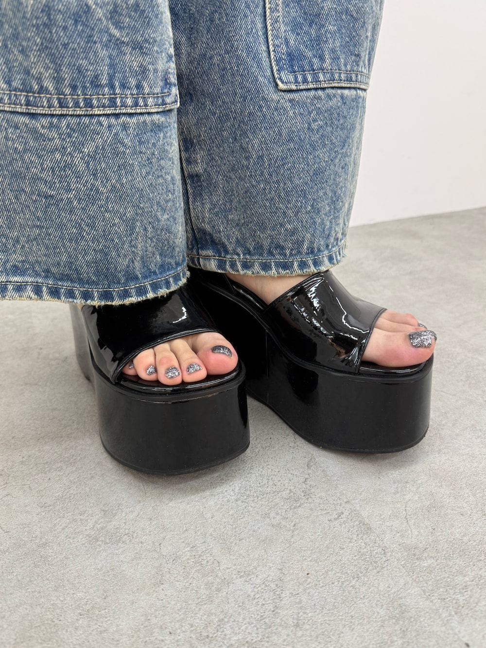 ブラック系のサンダル、ブルー系のデニムパンツ、ホワイト系のニット/セーターを着用したレディースの春コーディネートの6枚目の写真
