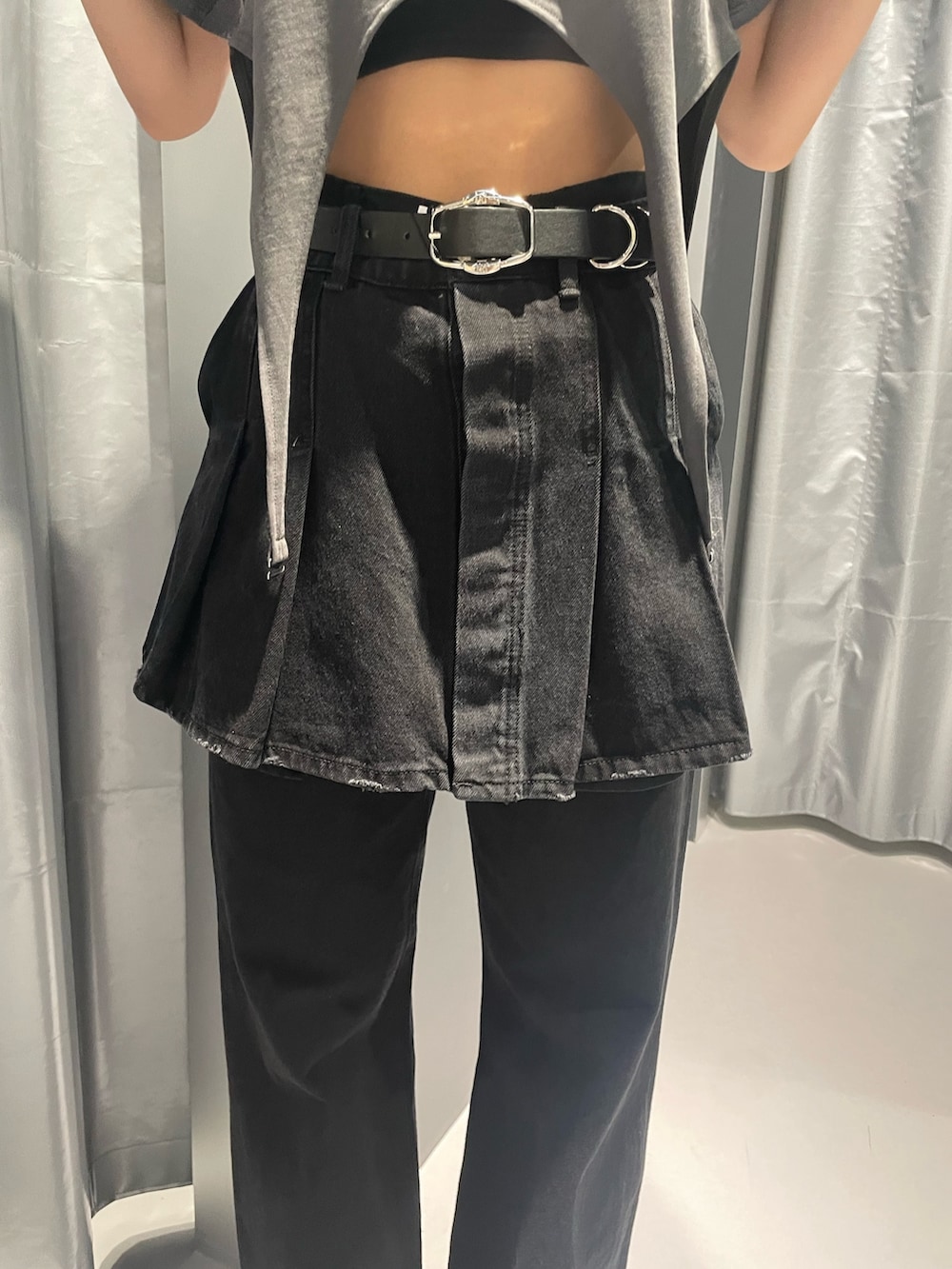 グレー系のTシャツ/カットソー、ブラック系のデニムスカート、ブラック系のデニムパンツを着用したレディースの春コーディネートの7枚目の写真