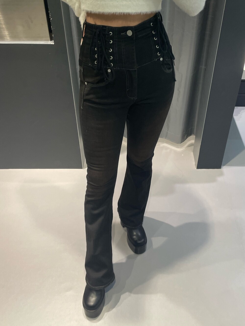 ホワイト系のニット/セーター、ブラウン系のダウンジャケット/コート、ブラック系のデニムパンツを着用したレディースの冬コーディネートの8枚目の写真