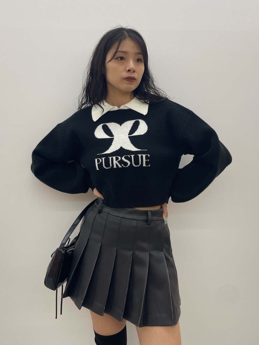 ブラック系のニット/セーター、グレー系のスカート、ブラック系のショルダーバッグを着用したレディースの夏コーディネートの4枚目の写真