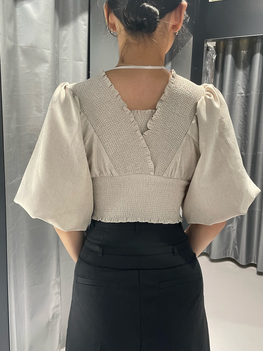 ベージュ系のTシャツ/カットソー、ブラック系のスカート、ブラック系のサンダルを着用したレディースの夏コーディネートの6枚目の写真