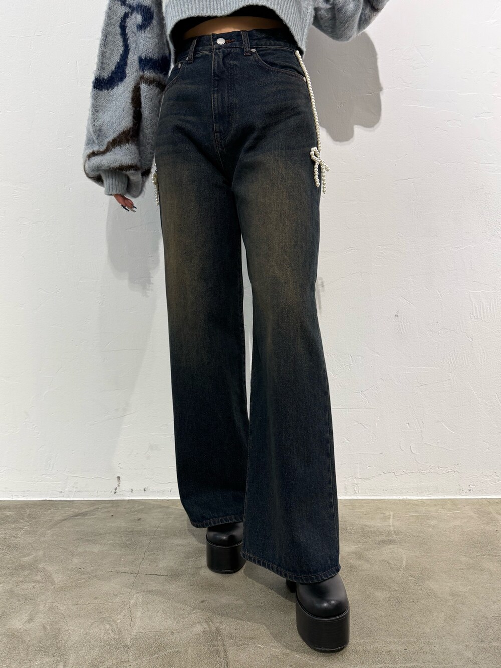 グレー系のニット/セーター、ブルー系のデニムパンツ、ブラック系のブーツを着用したレディースの秋コーディネートの6枚目の写真