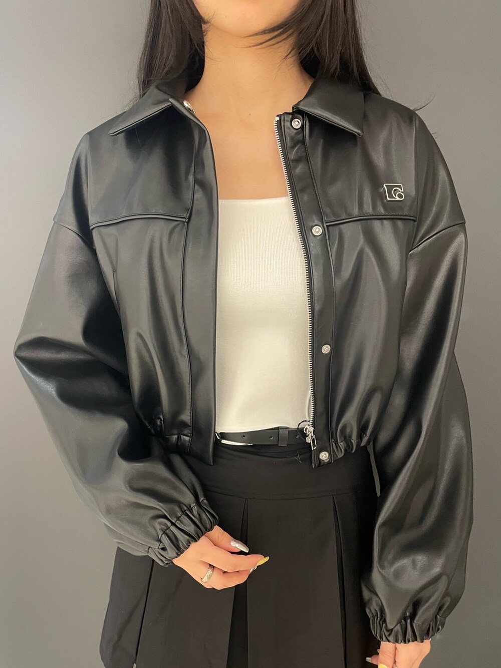 ホワイト系のタンクトップ、ブラック系のブルゾン、ブラック系のスカートを着用したレディースの春コーディネートの4枚目の写真