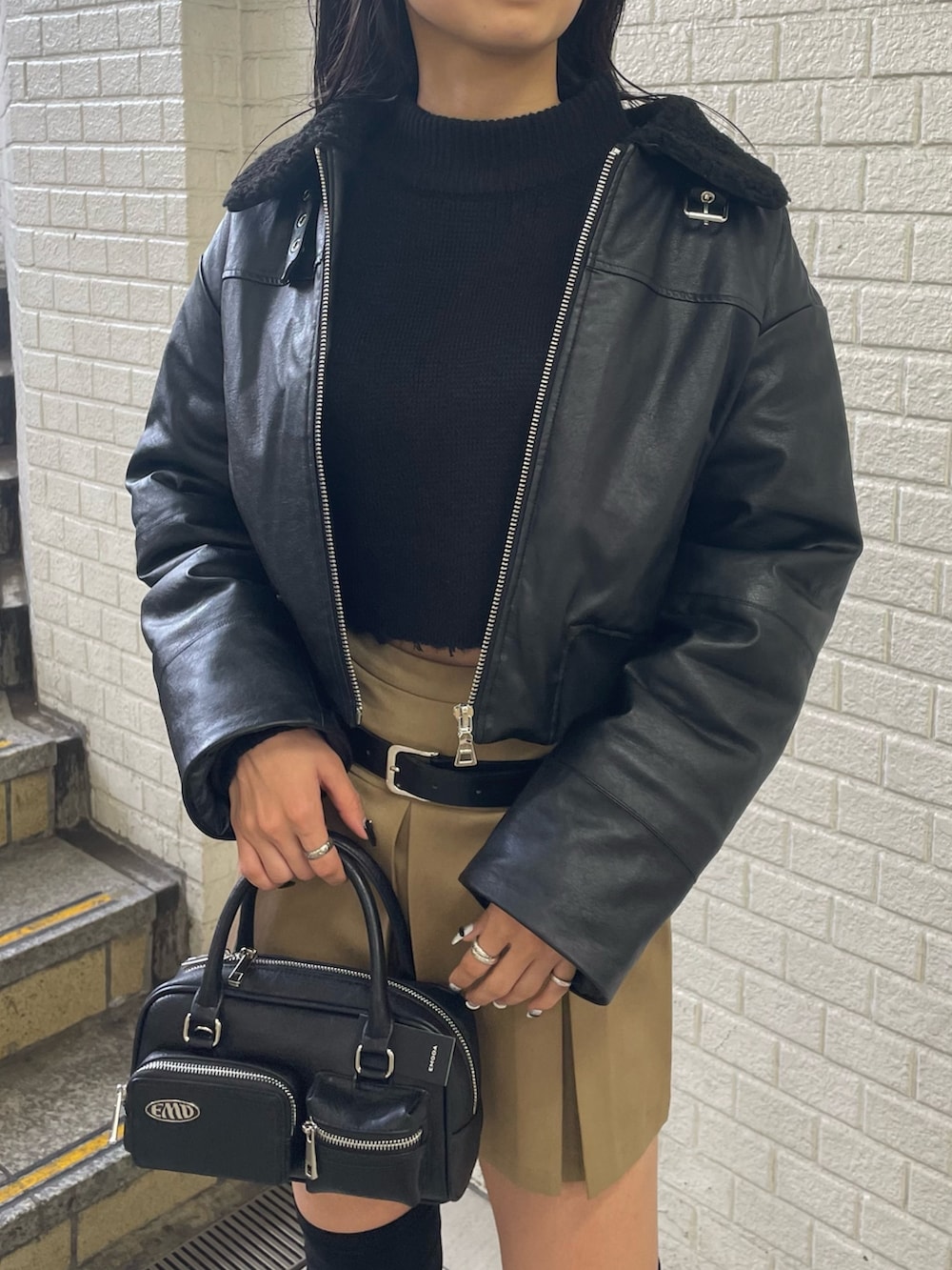 ブラック系のニット/セーター、ブラック系のブルゾン、ベージュ系のスカートを着用したレディースの秋コーディネートの4枚目の写真