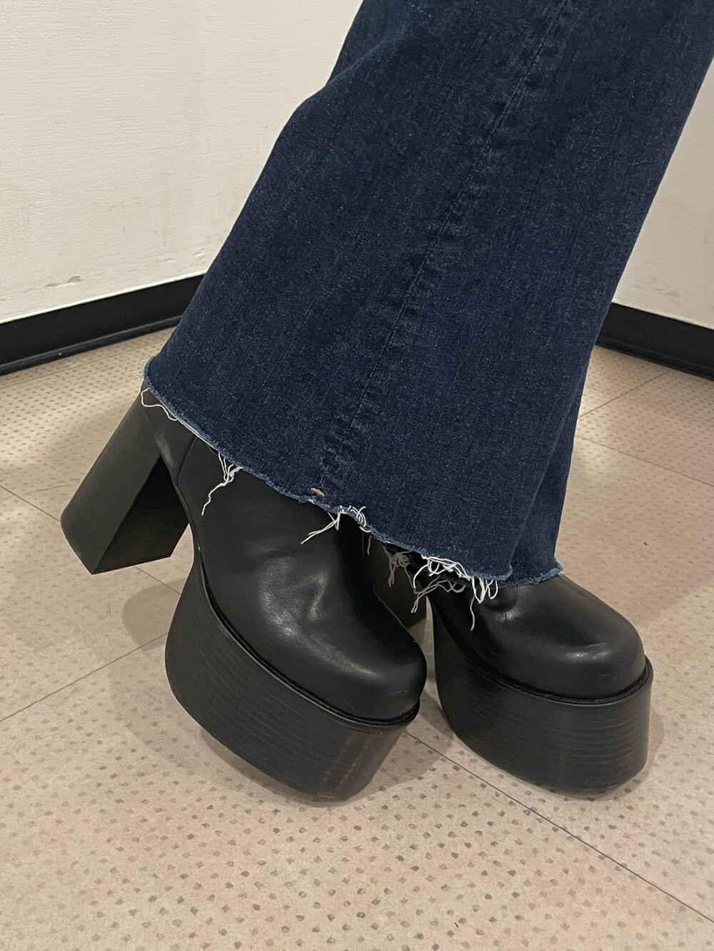 グリーン系のニット/セーター、ブルー系のデニムパンツ、ブラック系のブーツを着用したレディースの冬コーディネートの9枚目の写真