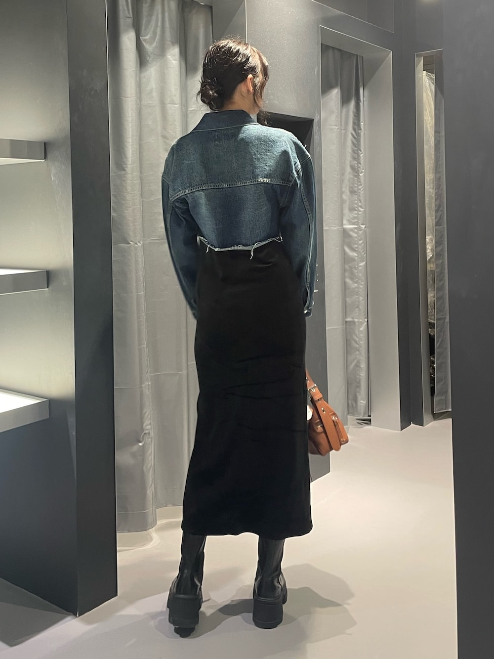 ブルー系のデニムジャケット、ブラック系のワンピース、イエロー系のハンドバッグを着用したレディースの秋コーディネートの3枚目の写真