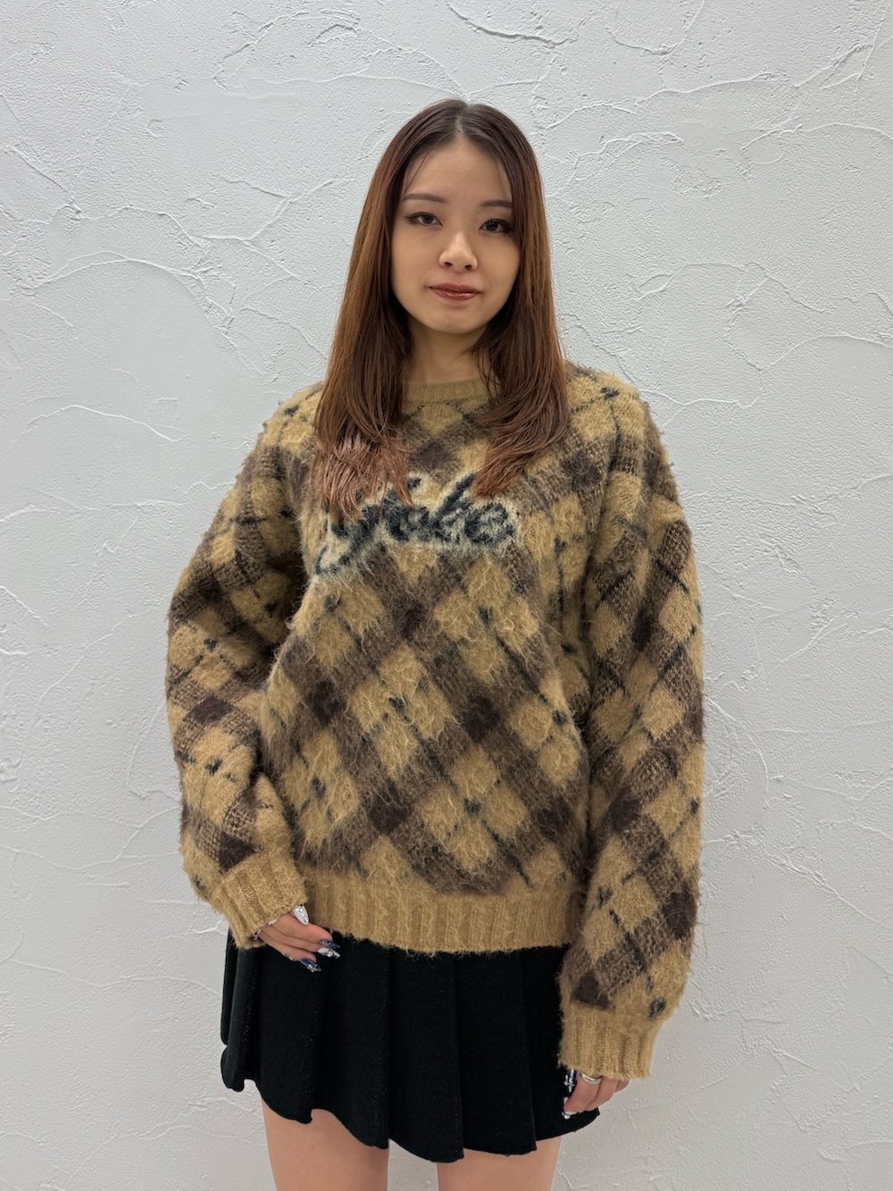 ベージュ系のニット/セーター、ブラック系のスカート、ホワイト系のブーツを着用したレディースの冬コーディネートの4枚目の写真