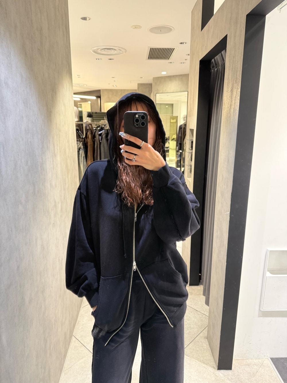 ブラック系のパーカー、ブラック系のスウェットパンツ、ブラック系のブーツを着用したレディースの秋コーディネートの4枚目の写真