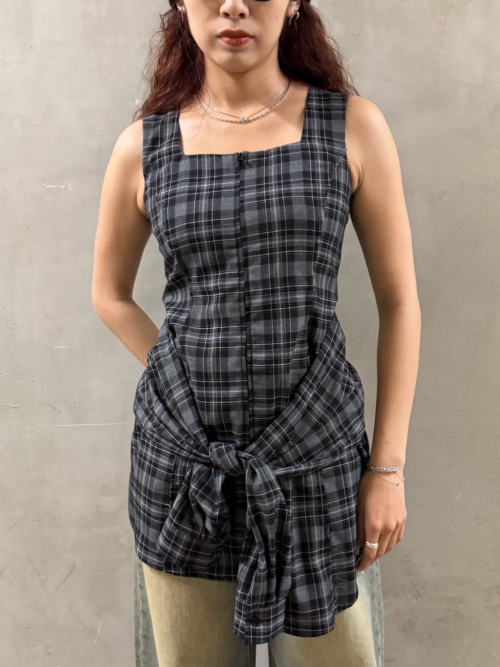 グレー系のワンピース、ブルー系のデニムパンツ、ブラック系のサンダルを着用したレディースの夏コーディネートの4枚目の写真