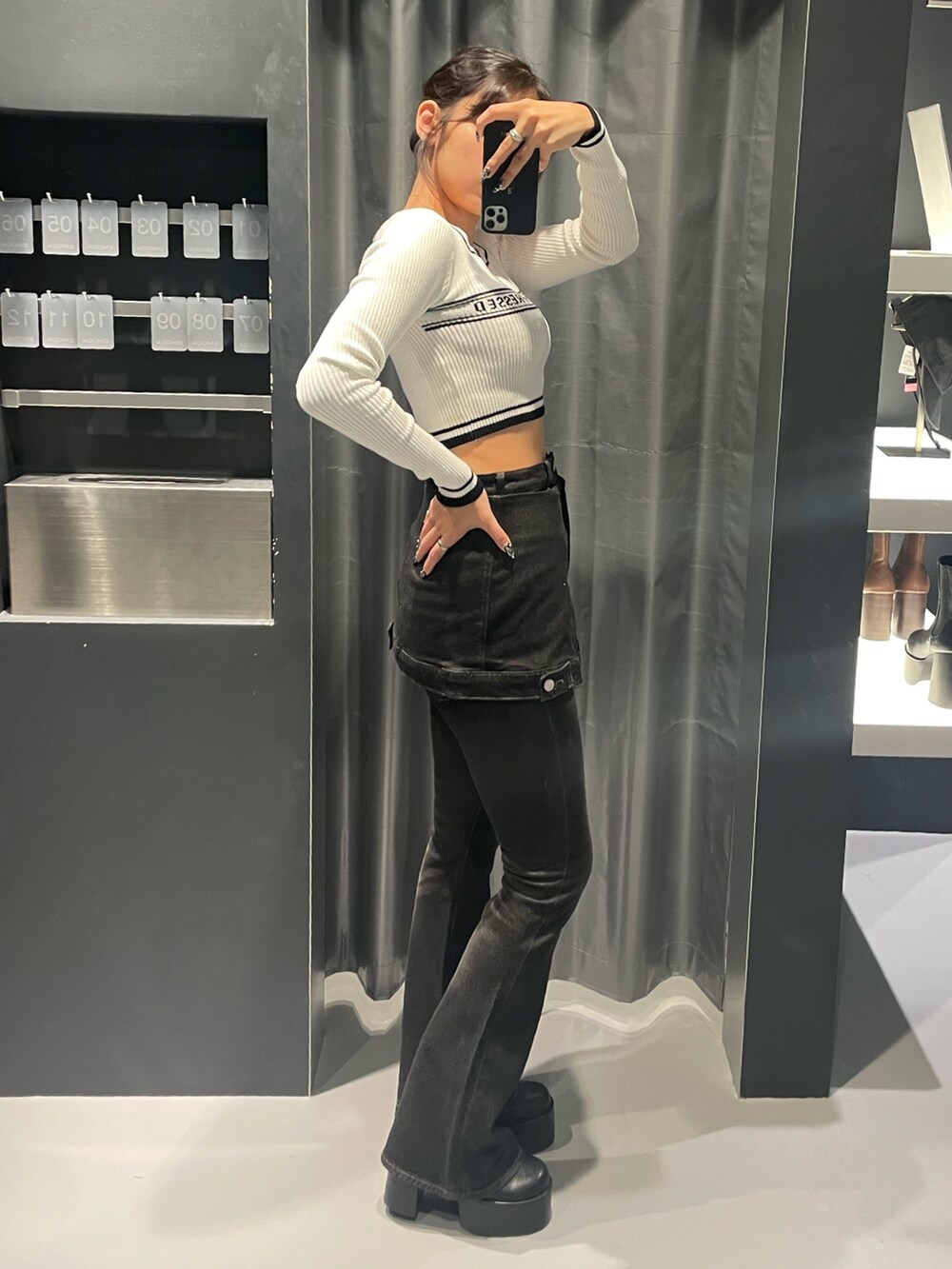 ホワイト系のニット/セーター、ブラック系のデニムパンツ、ブラック系のブーツを着用したレディースの秋コーディネートの2枚目の写真