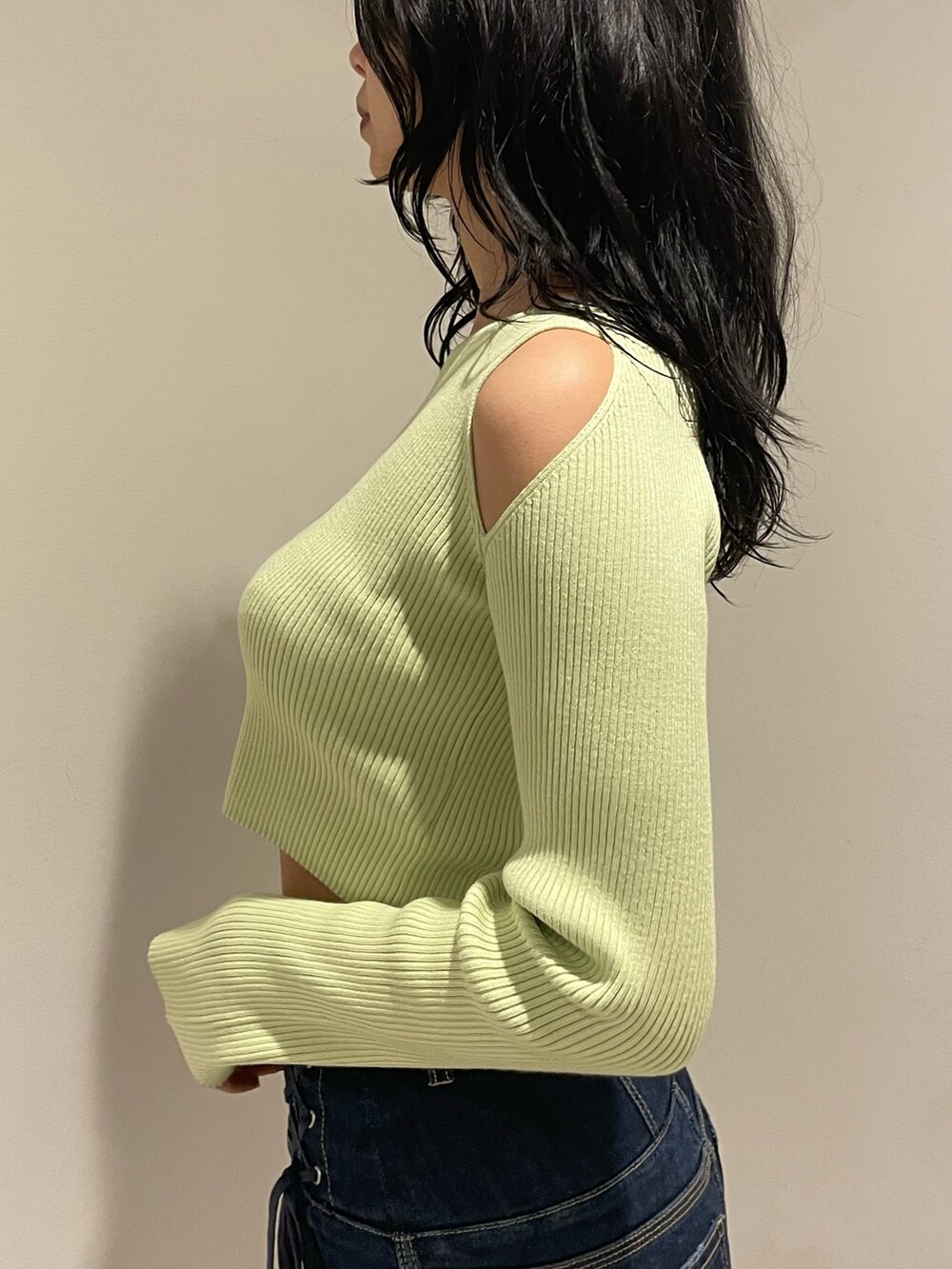 グリーン系のニット/セーター、ブルー系のデニムパンツ、ブラック系のブーツを着用したレディースの冬コーディネートの5枚目の写真