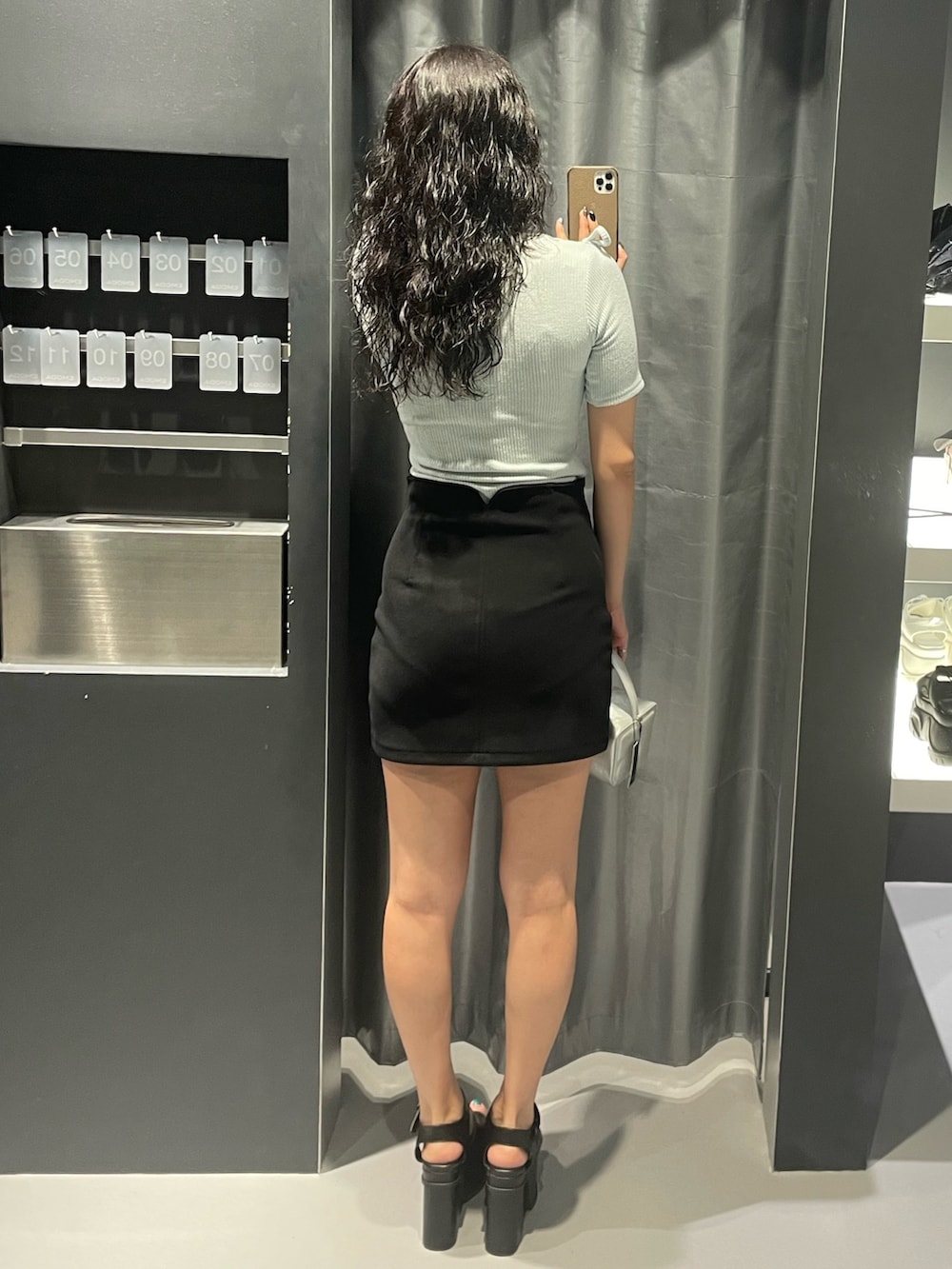 ブルー系のTシャツ/カットソー、ブラック系のスカート、シルバー系のハンドバッグを着用したレディースの夏コーディネートの3枚目の写真