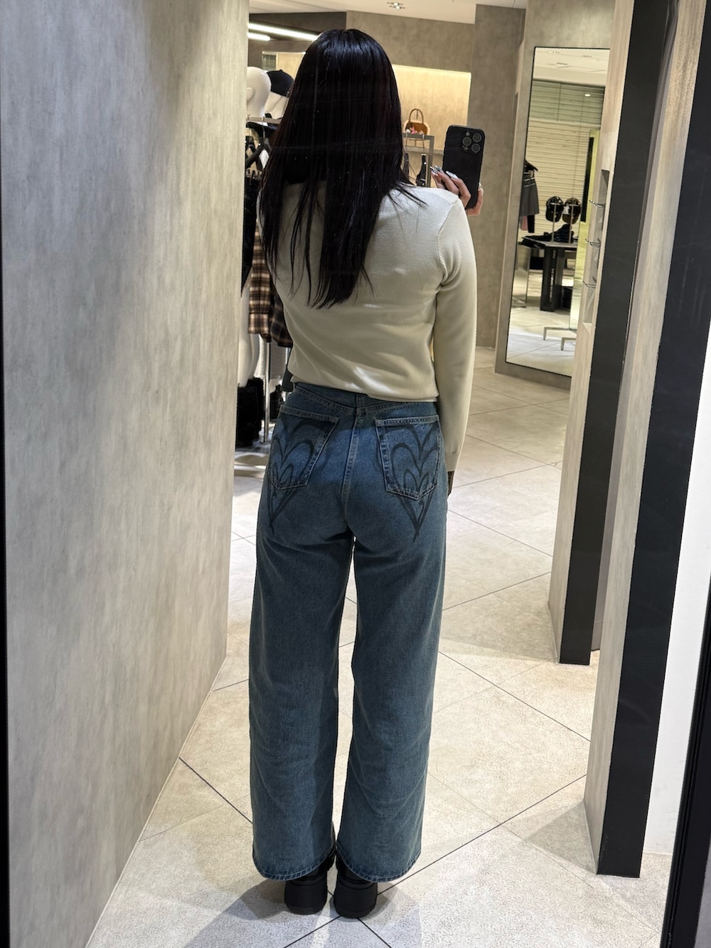 ベージュ系のシャツ/ブラウス、ブルー系のデニムパンツ、ブラック系のブーツを着用したレディースの冬コーディネートの3枚目の写真