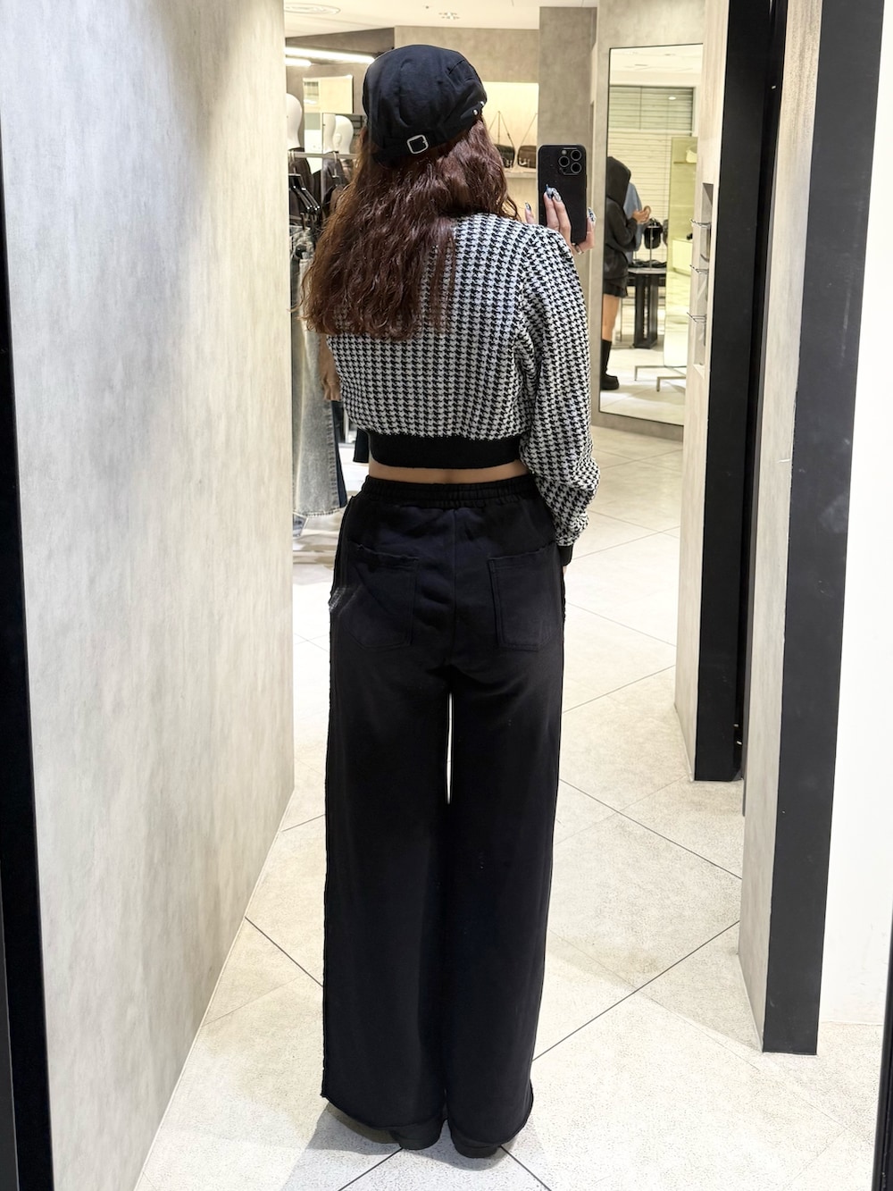 ブラック系のニット/セーター、ブラック系のスウェットパンツ、ブラック系のブーツを着用したレディースの秋コーディネートの3枚目の写真