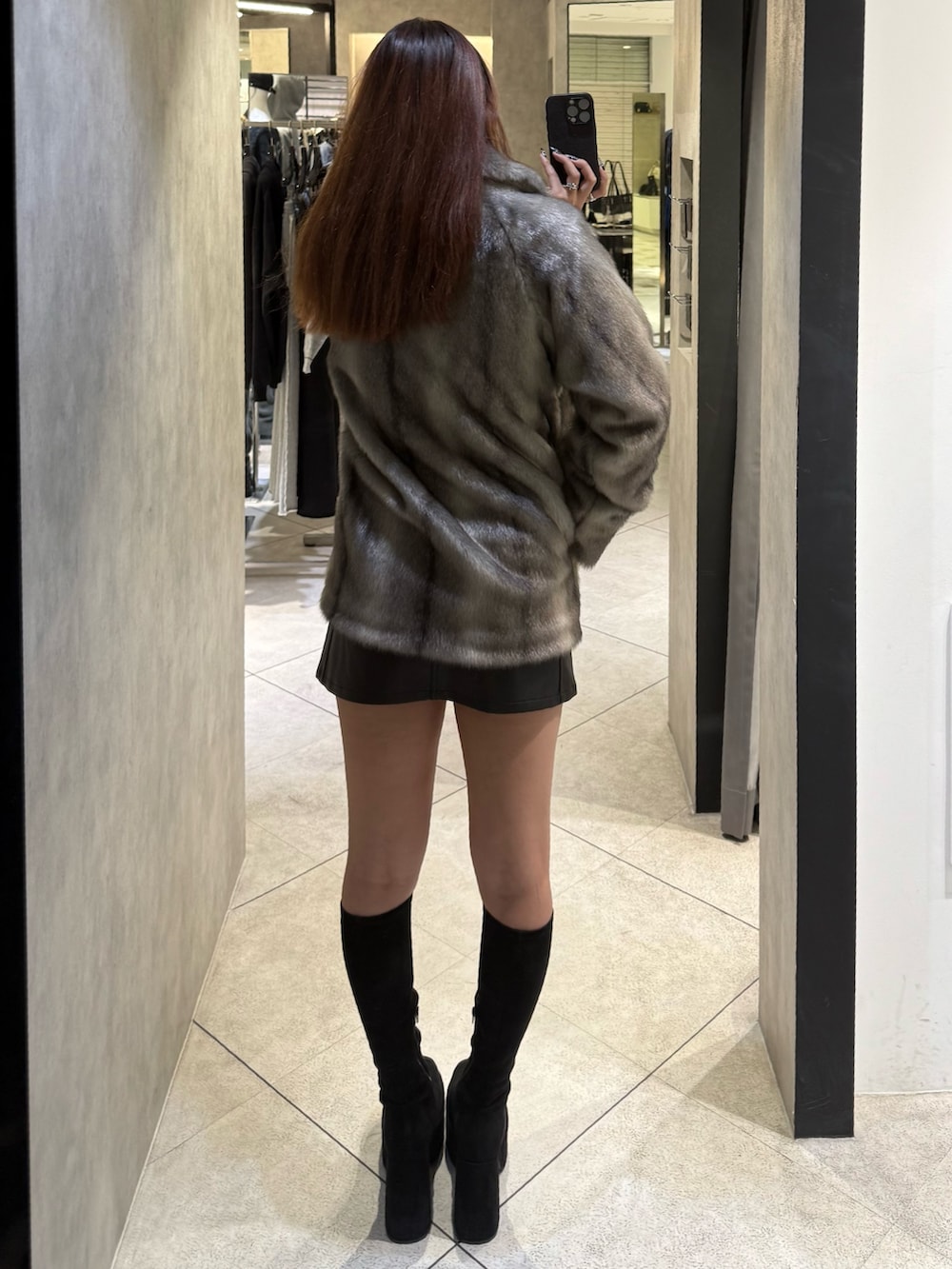 グレー系のその他アウター、ブラック系のスカート、ブラック系のブーツを着用したレディースの秋コーディネートの3枚目の写真