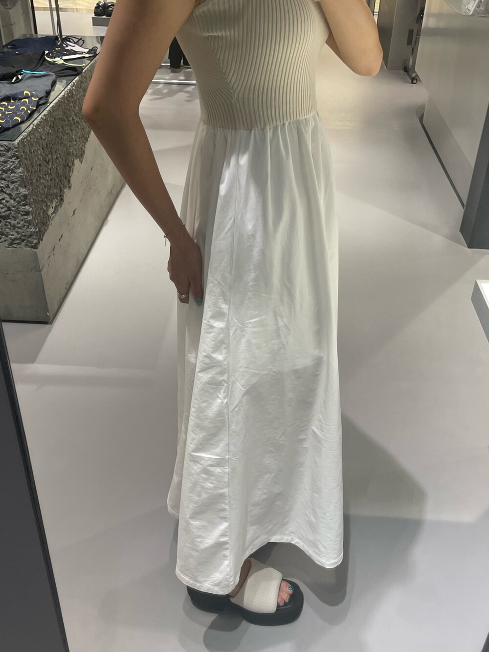 ホワイト系のワンピース、ホワイト系のサンダル、シルバー系のネックレスを着用したレディースの夏コーディネートの7枚目の写真