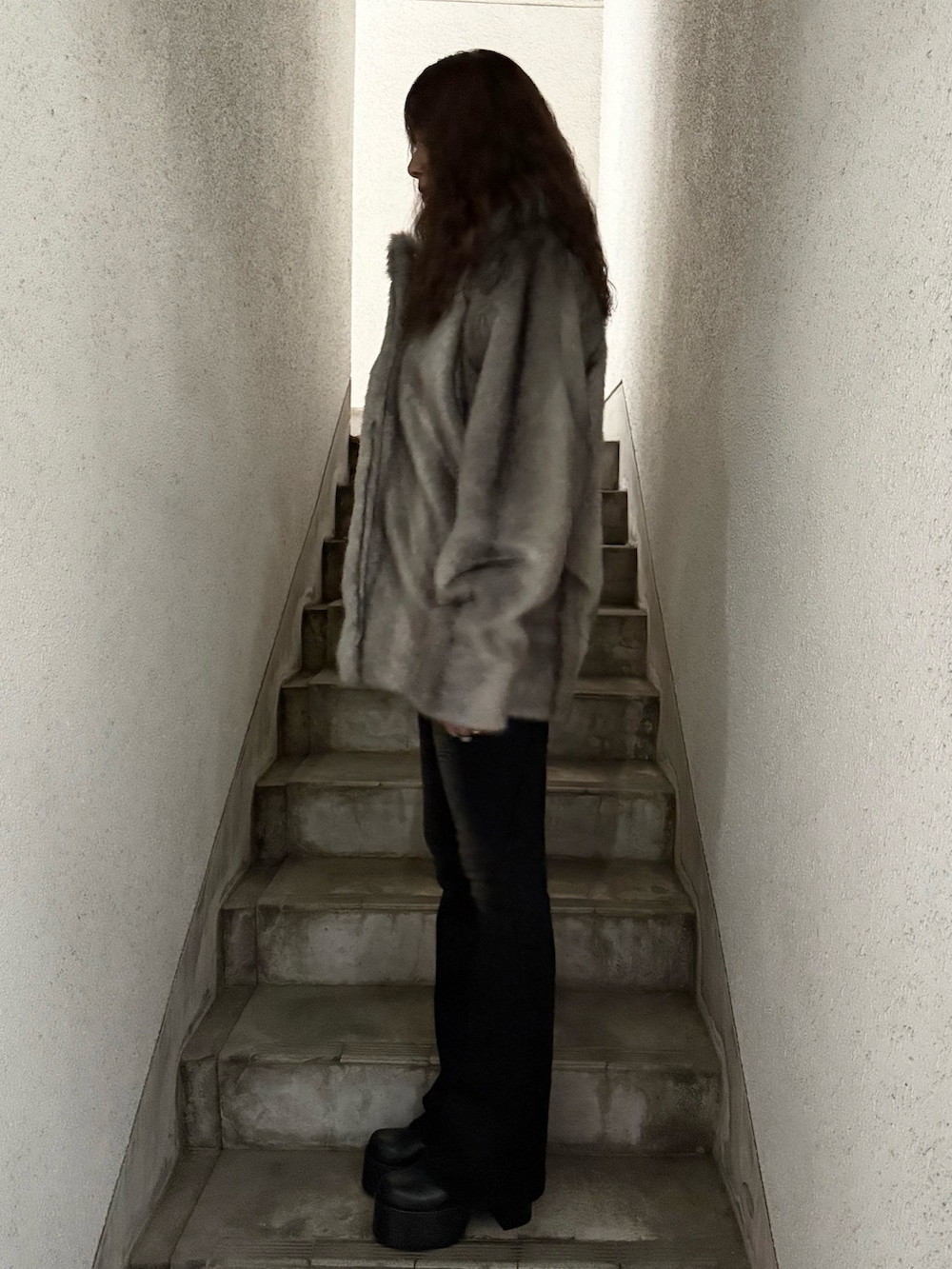 グレー系のその他アウター、ブラック系のデニムパンツ、ブラック系のブーツを着用したレディースの秋コーディネートの2枚目の写真