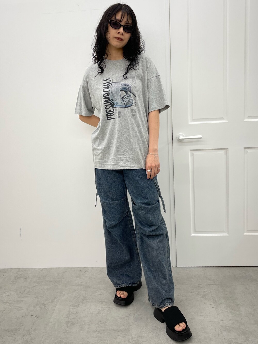 グレー系のTシャツ/カットソー、ブルー系のデニムパンツ、ブラック系のサンダルを着用したレディースの春コーディネートの7枚目の写真