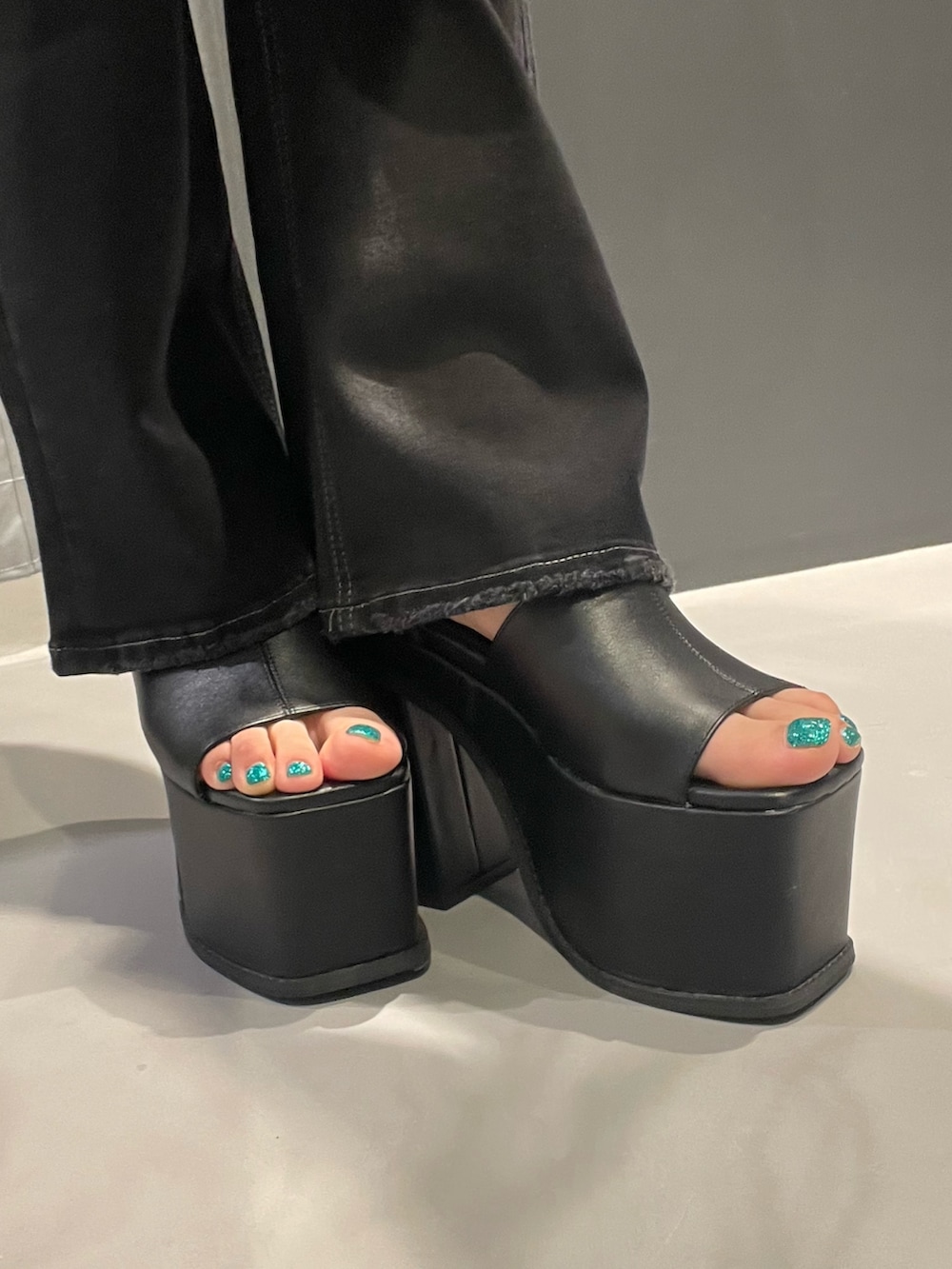 ブルー系のTシャツ/カットソー、ブラック系のスカート、シルバー系のハンドバッグを着用したレディースの夏コーディネートの8枚目の写真