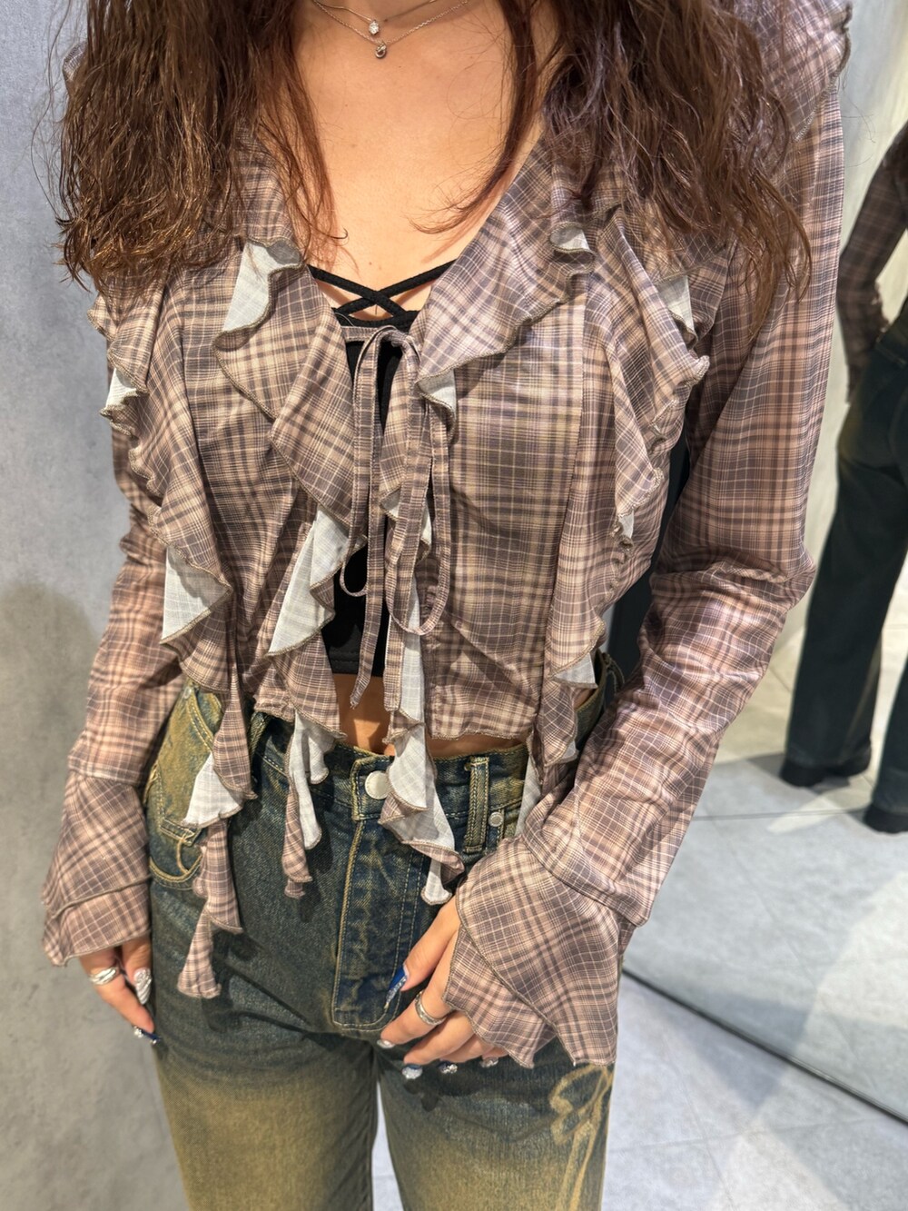 ベージュ系のシャツ/ブラウス、ブラック系のキャミソール、ブルー系のデニムパンツを着用したレディースの秋コーディネートの6枚目の写真