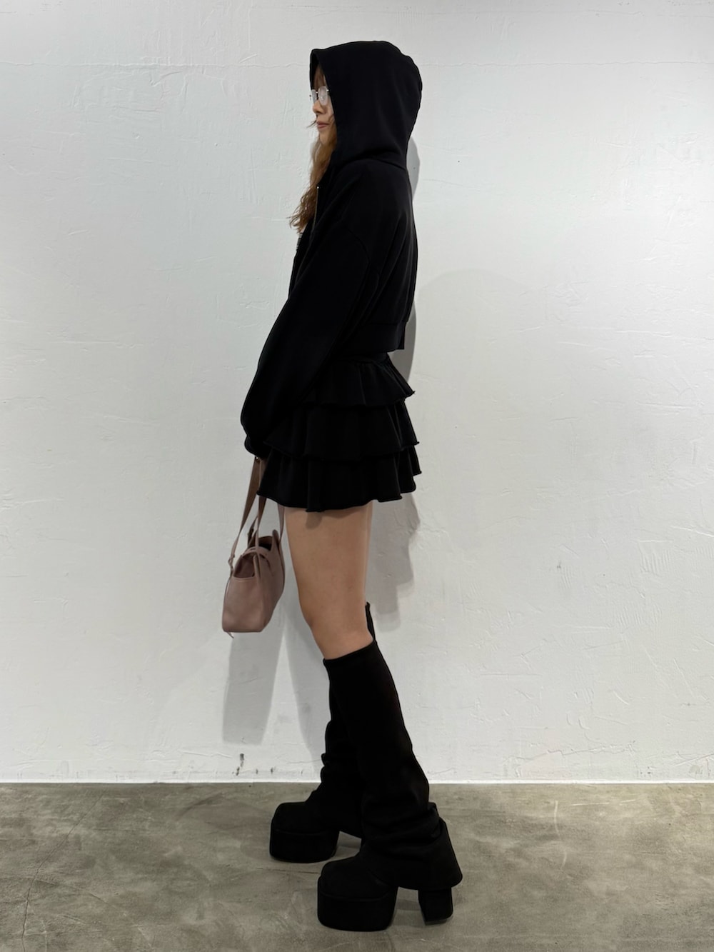 ピンク系のニット/セーター、ブラック系のパーカー、ブラック系のスカートを着用したレディースの秋コーディネートの2枚目の写真