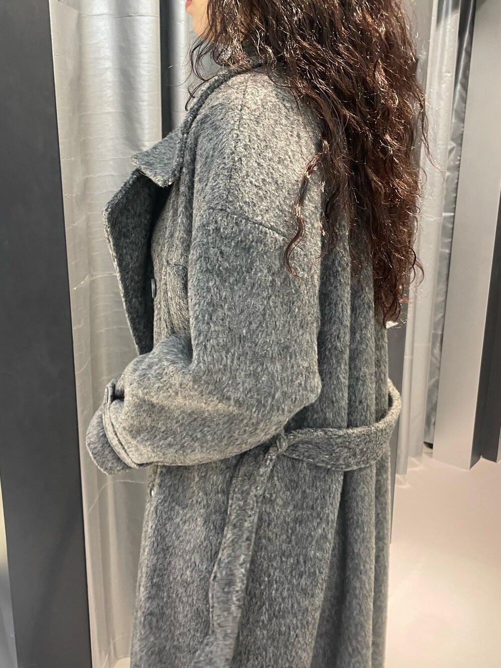 ブラック系のニット/セーター、グレー系のその他アウター、ブルー系のデニムパンツを着用したレディースの冬コーディネートの5枚目の写真