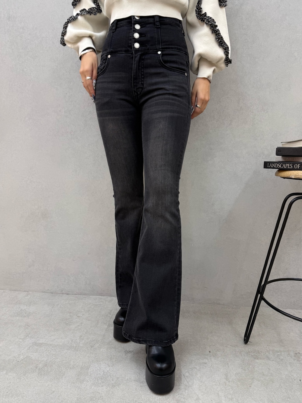 ブラック系のブーツ、ブラック系のデニムパンツ、ホワイト系のニット/セーターを着用したレディースの冬コーディネートの5枚目の写真