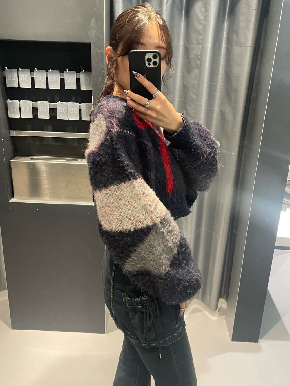 ブルー系のニット/セーター、ブルー系のデニムパンツ、ブラック系のブーツを着用したレディースの秋コーディネートの4枚目の写真